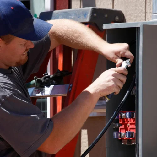 Electrician installing whole-home surge protection at an electrical panel