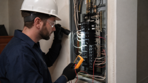 Licensed electrician performing a detailed electrical panel inspection with a multimeter in a San Diego home